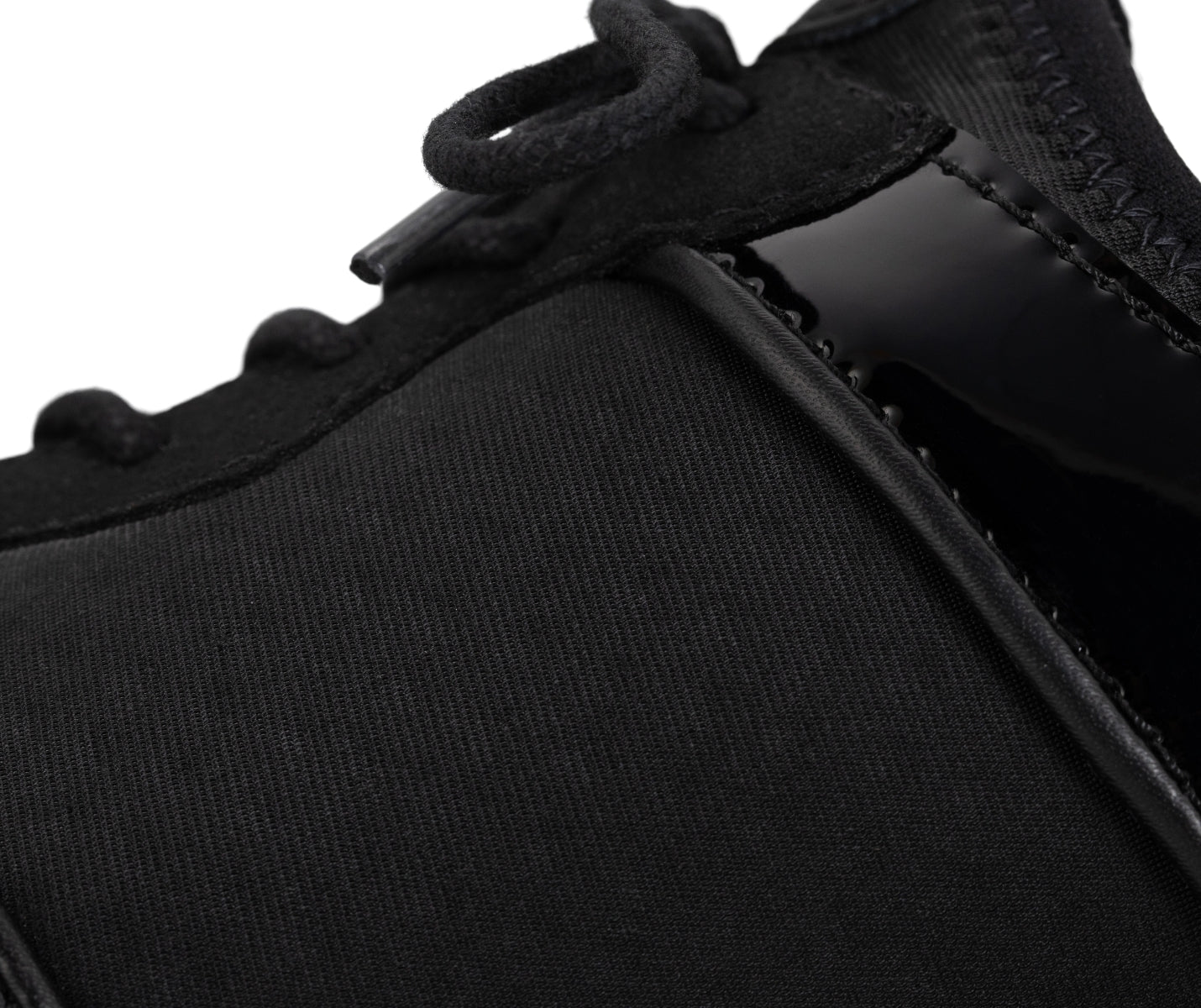 Nahaufnahme der Fuego Dance Sneakers Split Sole x Derek Hough von Fuego Dance Shoes in Schwarz mit Stoff- und Lackdetails.